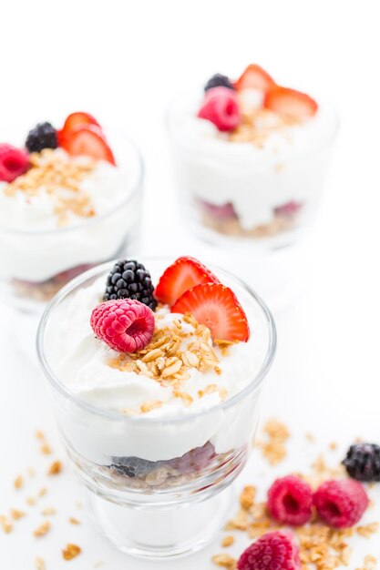 Ontbijtparfait gemaakt van Griekse yoghurt en granola met daarop verse bessen.