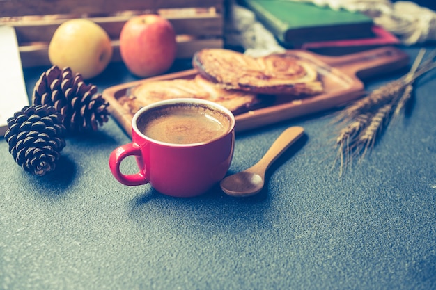 Ontbijtscène met koffiekop, brood en vruchten op de lijst. Vintage toon