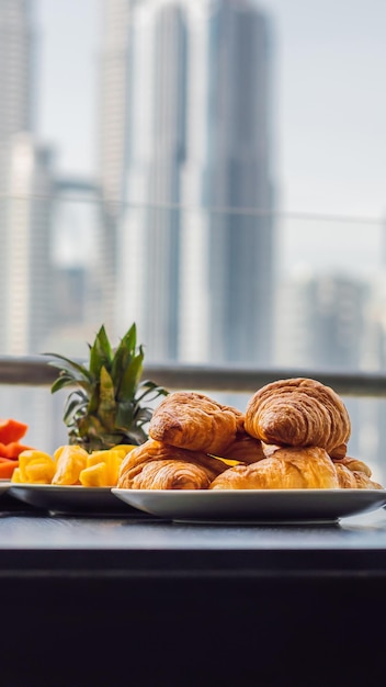 Ontbijttafel met koffiefruit en broodcroisant op een balkon tegen de achtergrond van de big