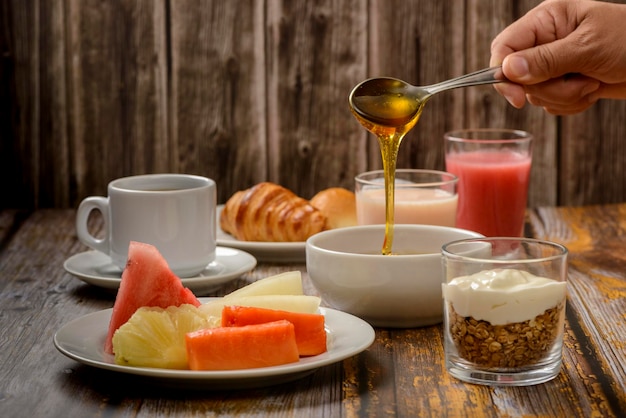 Ontbijttafel met nadruk op tropisch fruit en bijenhoning.