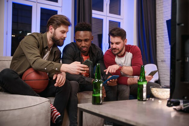 Ontevreden over het spel van het team dat internationale mannelijke vrienden bier drinken en op hun smartphones browsen terwijl ze naar het wereldkampioenschap op tv kijken.