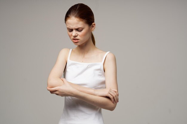 Ontevreden vrouw elleboogpijn artritis chronische ziekte lichte achtergrond foto van hoge kwaliteit