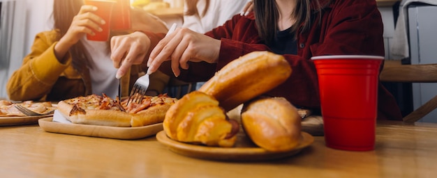 Ontmoetingsplaats voor vrienden Jonge vrouw viert verjaardagsfeest in het weekend thuis pizza eten drinken champagne party levensstijl vriendschap