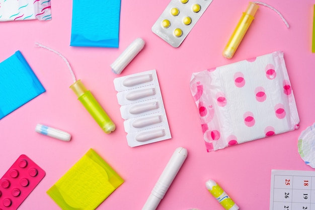 ÃÂ¡ontraceptive pills, hygienic pads and tampons on pink top view