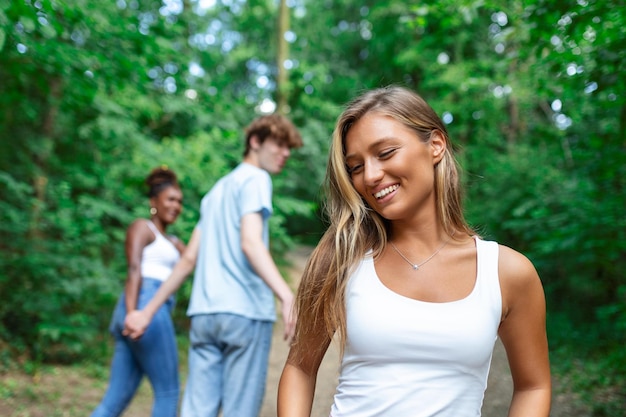 Ontrouwe man die naar een andere vrouw kijkt terwijl hij met zijn vriendin in het park wandelt