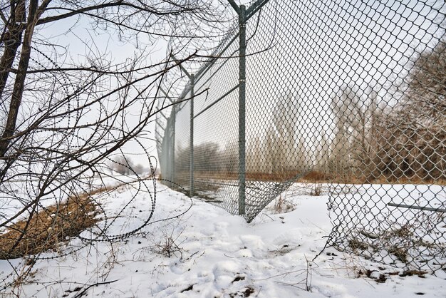 Foto ontsnapping uit gevangenis of gesloten inrichting voor geesteszieken gat in grenshek met prikkeldraad on...