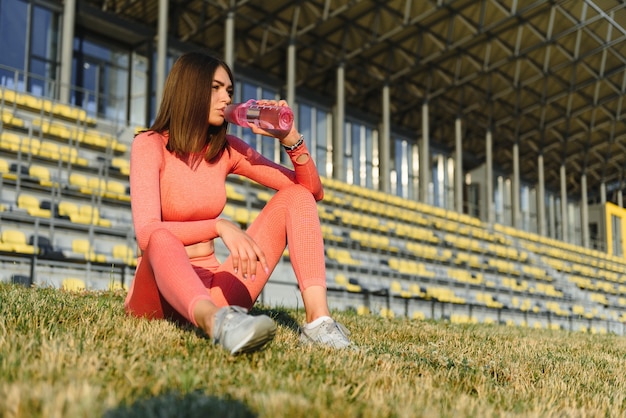 Ontspan in het gras - vermoeide vrouw na het sporten