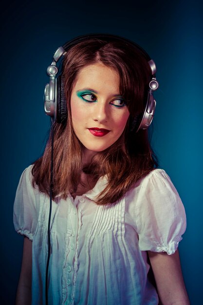 Ontspan, jong meisje luistert naar muziek met een enorme koptelefoon