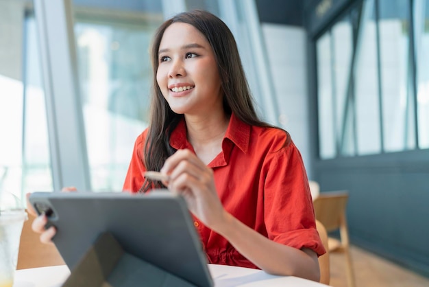 Ontspan vrije tijd aantrekkelijke slimme aziatische vrouwelijke freelance ondernemer glimlach en geniet van het werken met smartphone en laptop in café met vervagen stad zakelijke digitale nomade casual ideeën concept