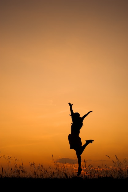 Ontspan vrouw en zonsondergang silhouet