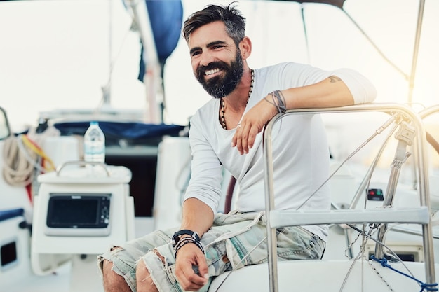 Ontspannen glimlachen en denken met de man op de boot op zee voor vakantie reis of vakantie in de zomer Gelukkig idee en rijk met zeeman persoon op luxe jacht voor oceaan avontuur sightseeing of toerisme