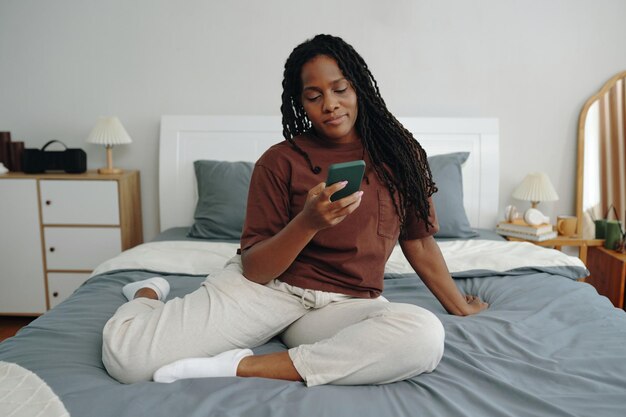 Ontspannen in bed terwijl je op je smartphone kijkt.