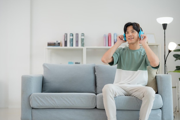 Ontspannen jonge man die thuis van muziek geniet