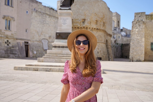 Ontspannen toeristenmeisje dat in de oude stad van Otranto, Apulië, Italië wandelt