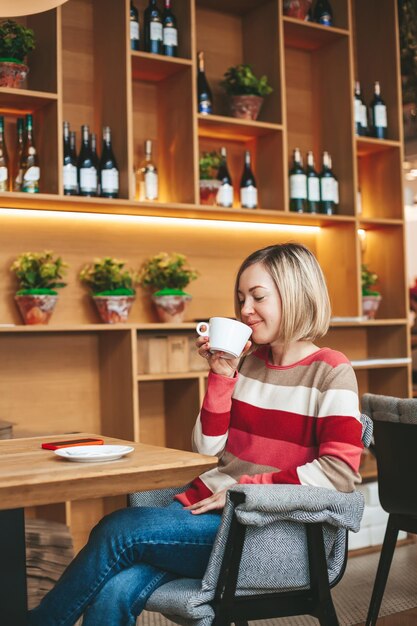 Ontspannen vrouw die koffie drinkt in café