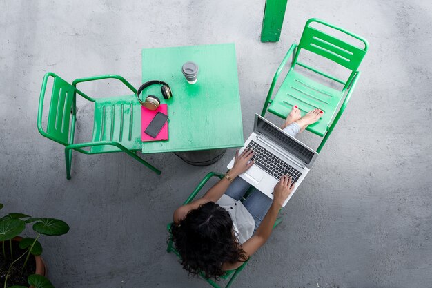 Ontspannen vrouw met behulp van haar laptop op het terras