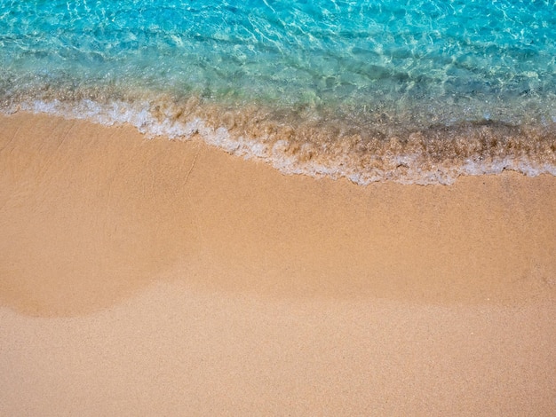 Ontspannende strandscène bovenaanzicht Beweging van blauw zeewater en golfbranding op schoon zandstrand oceaan kust kustlijn zomervakantie vakantie achtergrond met kopie ruimte