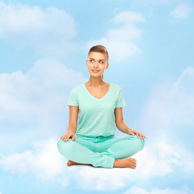 ontspanning, meditatie en lifestyle concept - meisje op de wolk in lotushouding en mediteren
