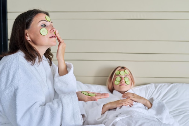 Ontspanning samen schoonheidsbehandelingen moeder en tienerdochter verzorgen het gezicht met natuurlijke cosmetica en komkommermaskers schoonheid schone spa huidverzorging ouder tiener kind communicatie