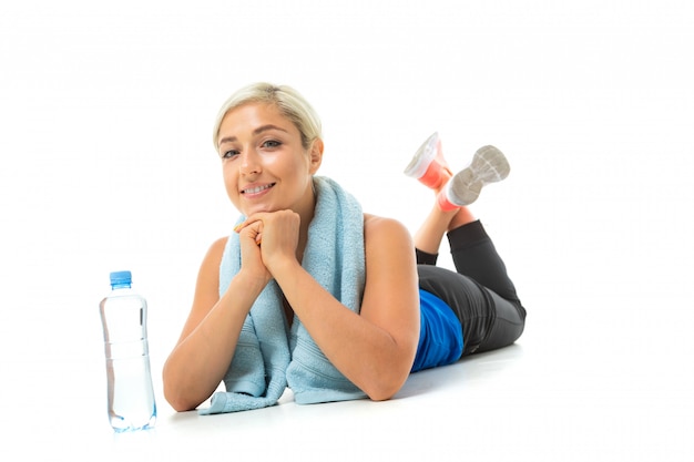 Ontspant de sport Kaukasische vrouw met handdoek en water na harde training