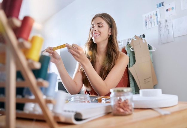 Ontwerpervrouw meet en plakband in werkplaats klein bedrijf of fabriek met geluk op het werk Creatief meisje ontwerpmaat of maat voor stofmateriaal of mode-industrie voor werken in studio