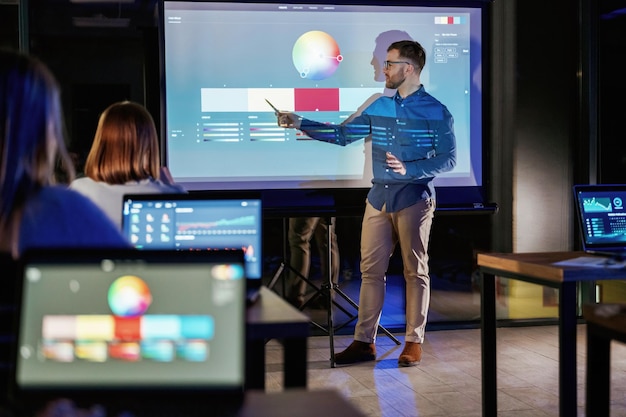 Ontwerpgereedschap Mannelijke business trainer is tegen projector met gegevens onderwijs mensen