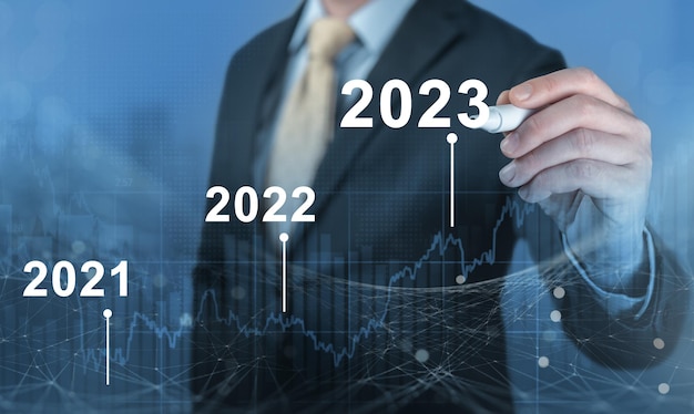 Ontwikkeling van succesvolle economische groei in 2022 2023 concept Zakenman prognose analyseplan winstgrafiek met pen en toename van positieve indicatoren Herstel van de economie na een val