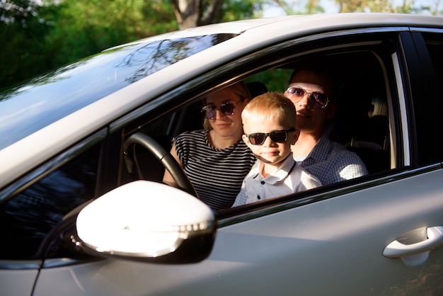 Onveilig rijden. Een klein kind zit in de armen van haar moeder op de bestuurdersstoel.