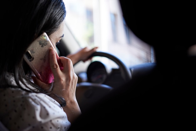 Onveilig rijden jonge multiraciale vrouw praten aan de telefoon tijdens het rijden afgeleid rijdende vrouw