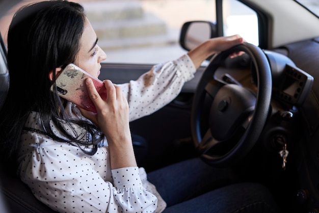 Onveilig rijden jonge multiraciale vrouw praten aan de telefoon tijdens het rijden afgeleid rijdende vrouw