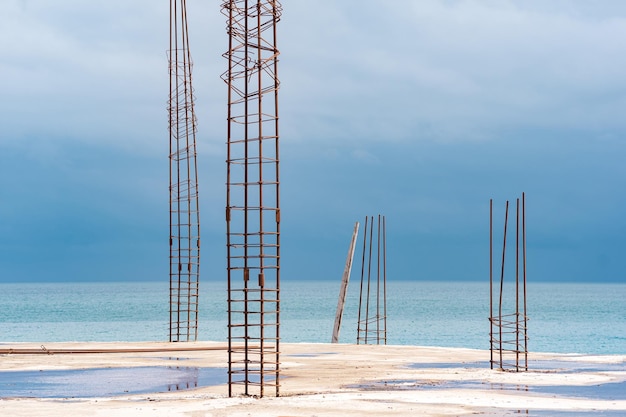 Onvoltooid gebouw met uitstekende wapening aan de kust