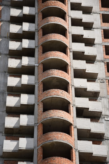 Onvoltooide hoogbouw met bakstenen muren, balkons en ongeglazuurde ramen