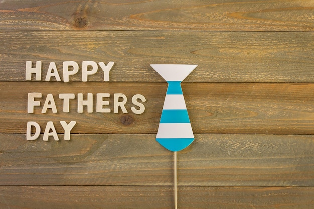 Onvoltooide houten letters ondertekenen Happy Father's Day op een geschilderde houten achtergrond.