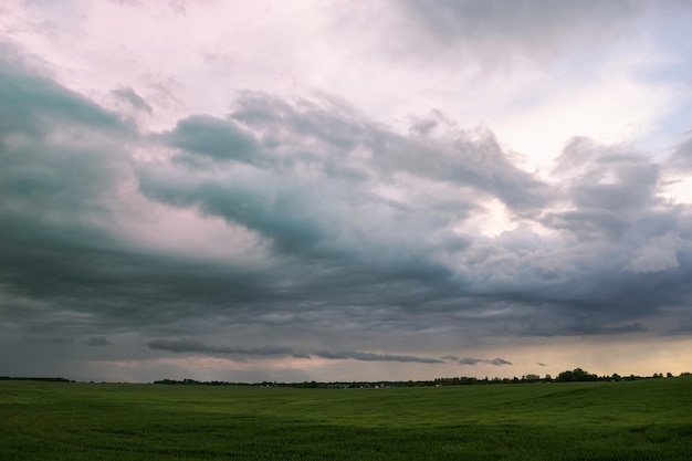 Onweerswolken over de weilanden. Landschap. Voor de regen. Weersomstandigheden, cycloon. Horizontale foto.