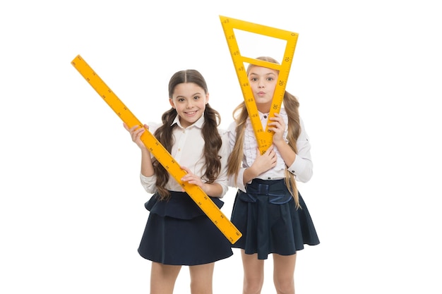 Onze favoriete les Kleine meisjes die zich op meetkundeles voorbereiden Leuke schoolmeisjes die driehoekig en liniaal voor les houden Kleine kinderen met meetinstrumenten op schoolles