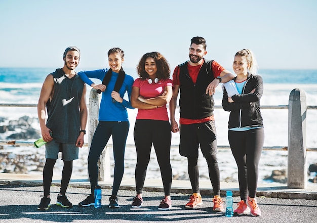 Onze toewijding is wat ons bij elkaar houdt Shot van een fitnessgroep die bij elkaar staat tijdens het hardlopen