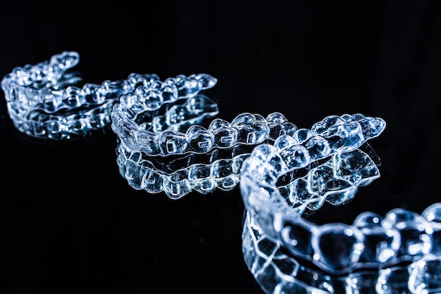 Onzichtbare aligners tandenhouders liggen op de spiegel