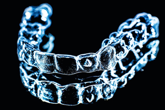 Onzichtbare tandheelkundige tanden beugels tanduitlijners op zwarte achtergrond Kunststof accolades tandheelkundehouders om tanden recht te zetten