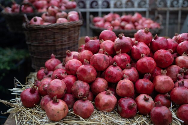 Oogst van rijpe granaatappels op droog stro op een buitenboerenmarkt in Turkije vegetarische gezonde voeding