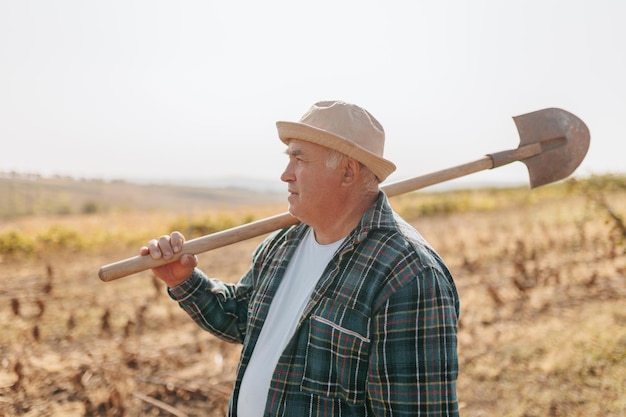 Oogsttijd een ervaren boer met een schop klaar om zijn overvloedige velden vast te houden