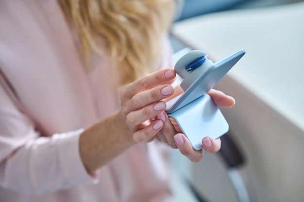 Foto oor model. menselijk oormodel van moderne kwaliteit op witte standaard in handen van vrouw op lichte achtergrond, geen gezicht