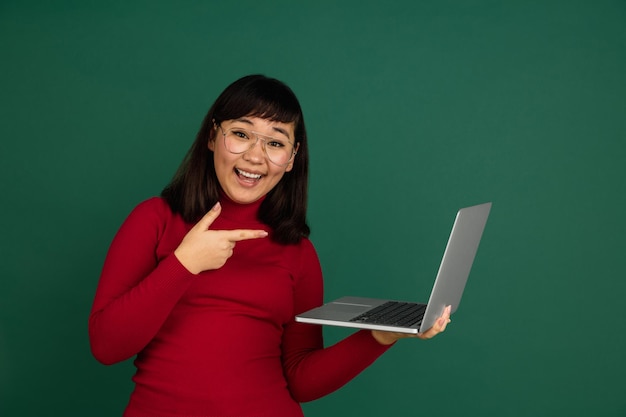 Oost-aziatische vrouw portret geïsoleerd op groene studio achtergrond met copyspace