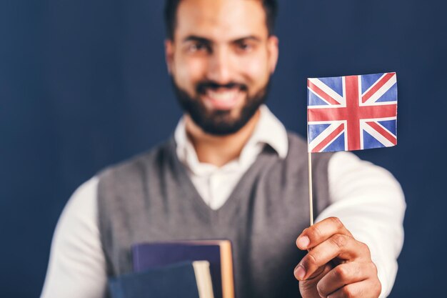Oosterse bebaarde man met Engelse vlag succesvolle taalleerconcept studio geïsoleerde achtergrond