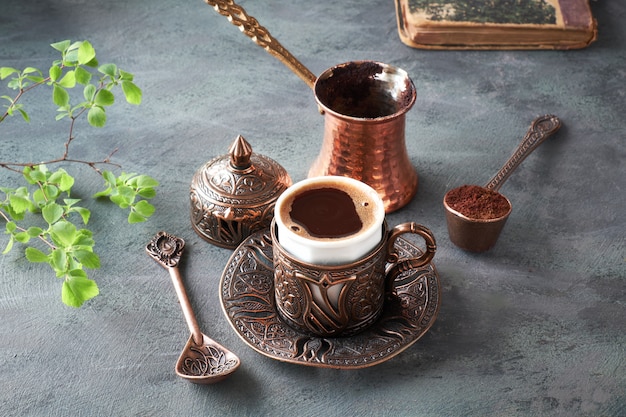 Oosterse koffie gekookt in traditionele Turkse koperen koffiepot en geserveerd in een bijpassende kop