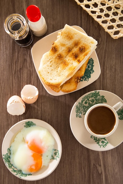 Oosterse ontbijtset in Maleisië bestaande uit koffie nasi lemak toastbrood en halfgekookt ei