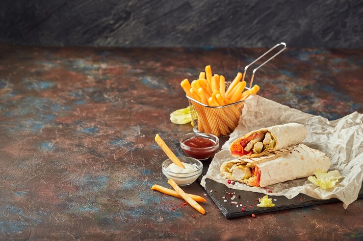 Oosterse traditionele shoarma met kip en groenten en frietjes met sauzen op leisteen. Fast food. Oosters eten.