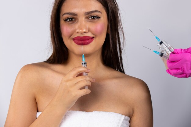 Op de afbeelding van de handen van een schoonheidsspecialiste die een cosmetische injectie vasthoudt. Het lelijke uiterlijk van de nieuwe normale schoonheid tegenwoordig. Cosmetologie, schoonheid, spa-concept. Hoge kwaliteit foto