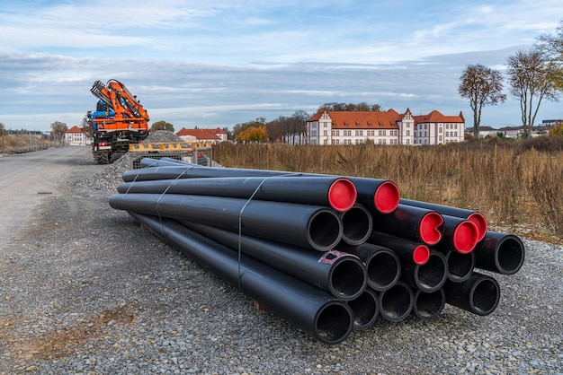 Op de bouwplaats liggen zwarte kunststof buizen met rode pluggen