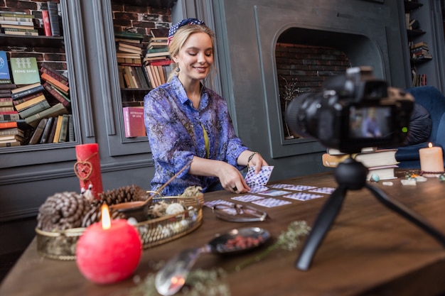 Op de camera. Opgetogen jonge vrouw die de toekomst voorspelt terwijl ze wordt opgenomen op de camera