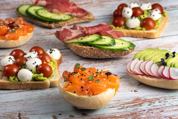 Foto op de houten tafel lag een assortiment sandwiches met vis, kaas, vlees en groenten